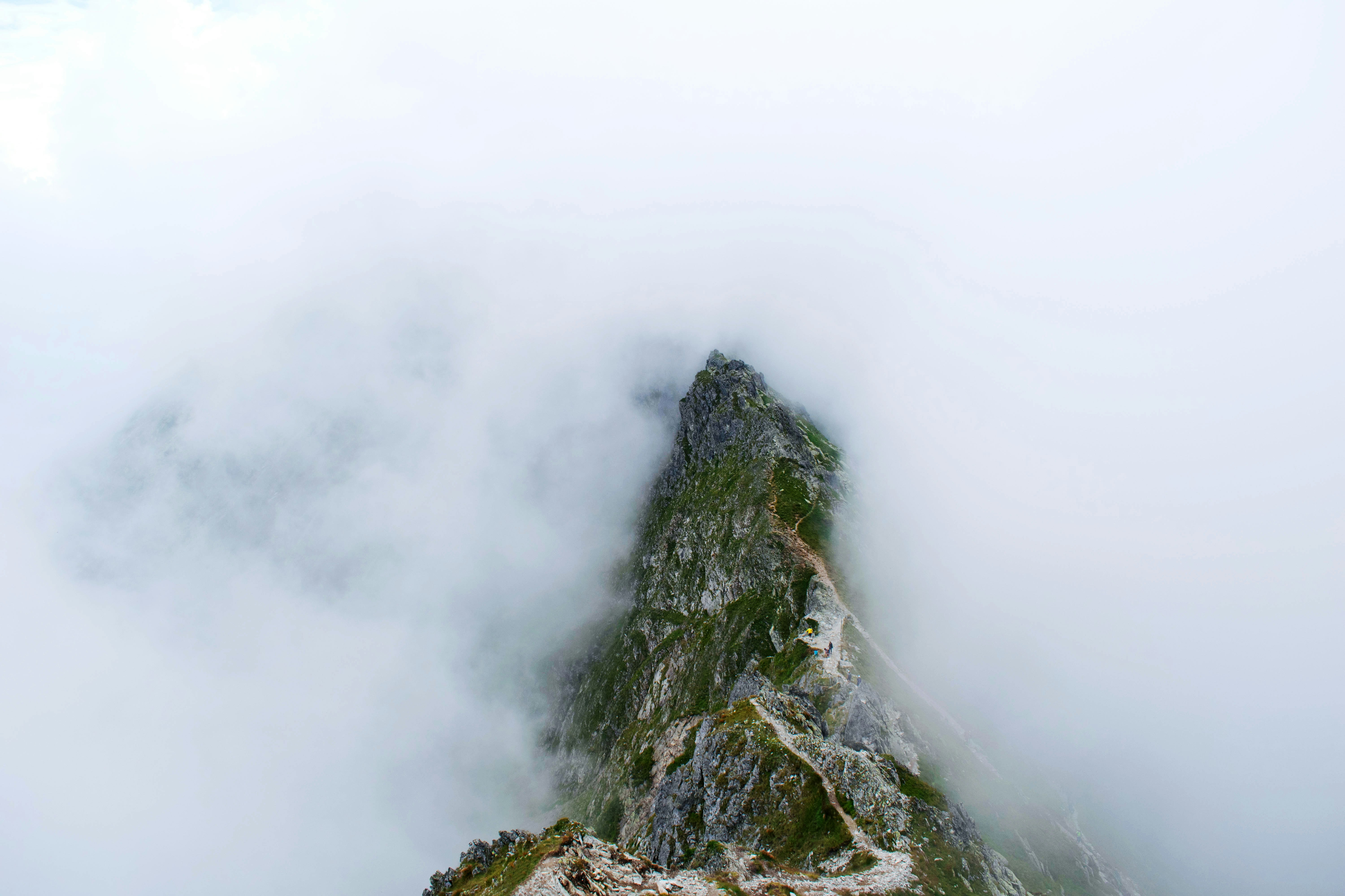 gray rocky mountain covered with white clouds